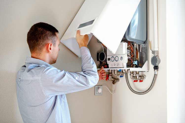 A technician repairs a gas boiler in a room, addressing unfamiliar noises emanating from the appliance.