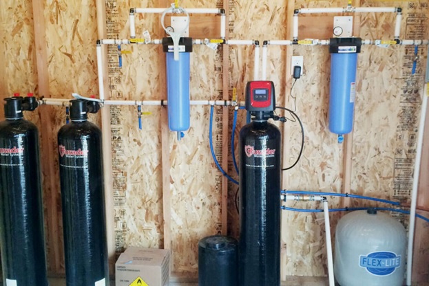 A water softener installed in a basement, showcasing its compact design and efficient water treatment capabilities.