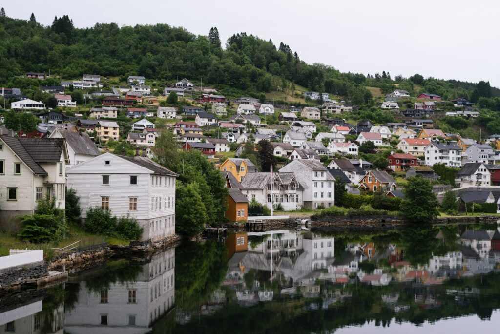 Tranquil scene of town mirrored in water on hillside, peaceful setting.